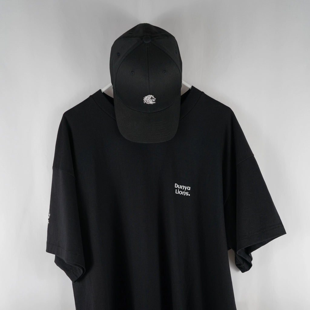 DL_Tee_Results_FrontWithCap01
Alt-Text: Front view of the Dunya Lions black t-shirt with small chest print, paired with matching black cap.