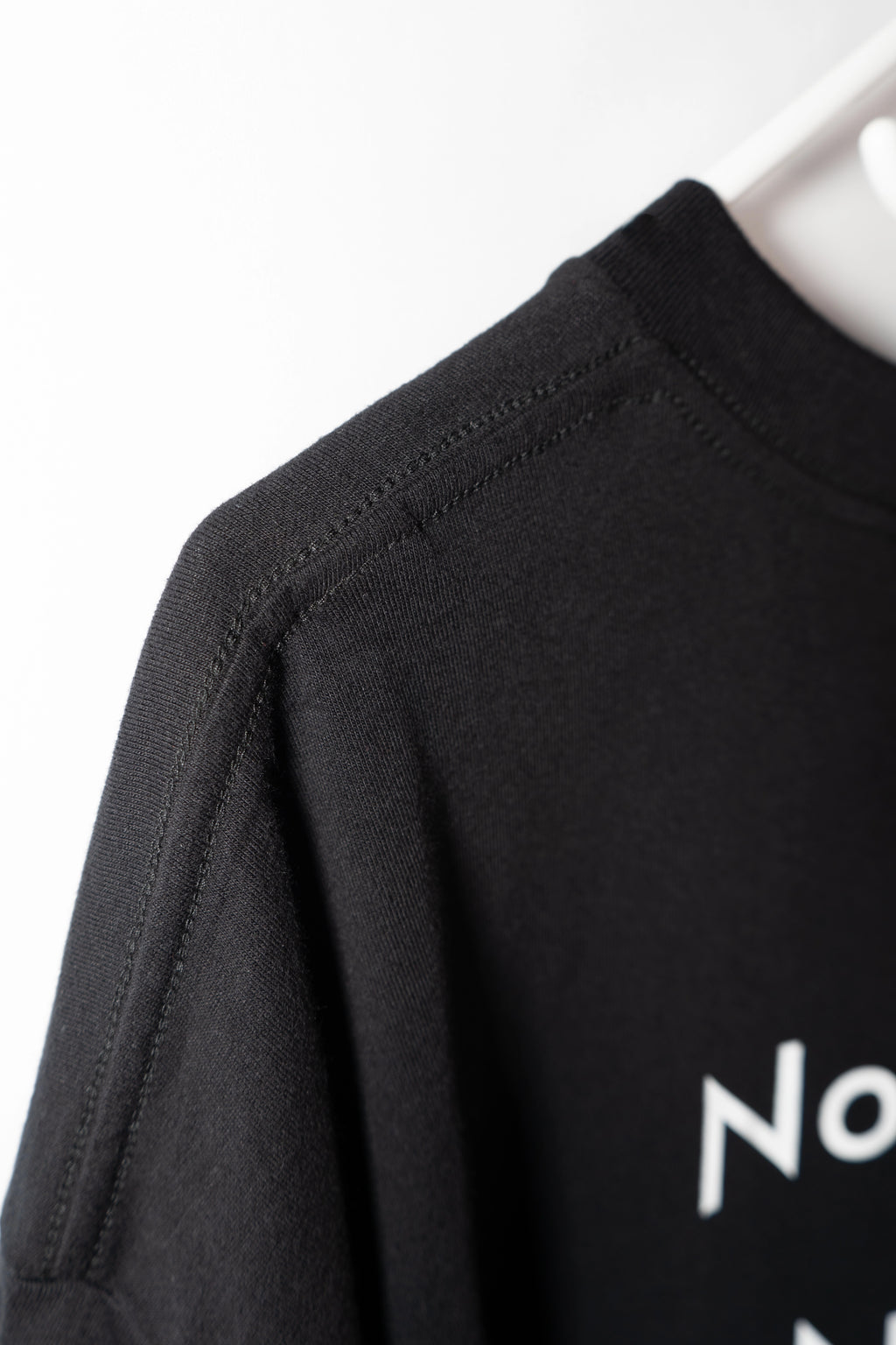DL_Tee_Results_SideNeckDetail04
Alt-Text: Side close-up of the Dunya Lions t-shirt collar with partial print: "No..." visible.