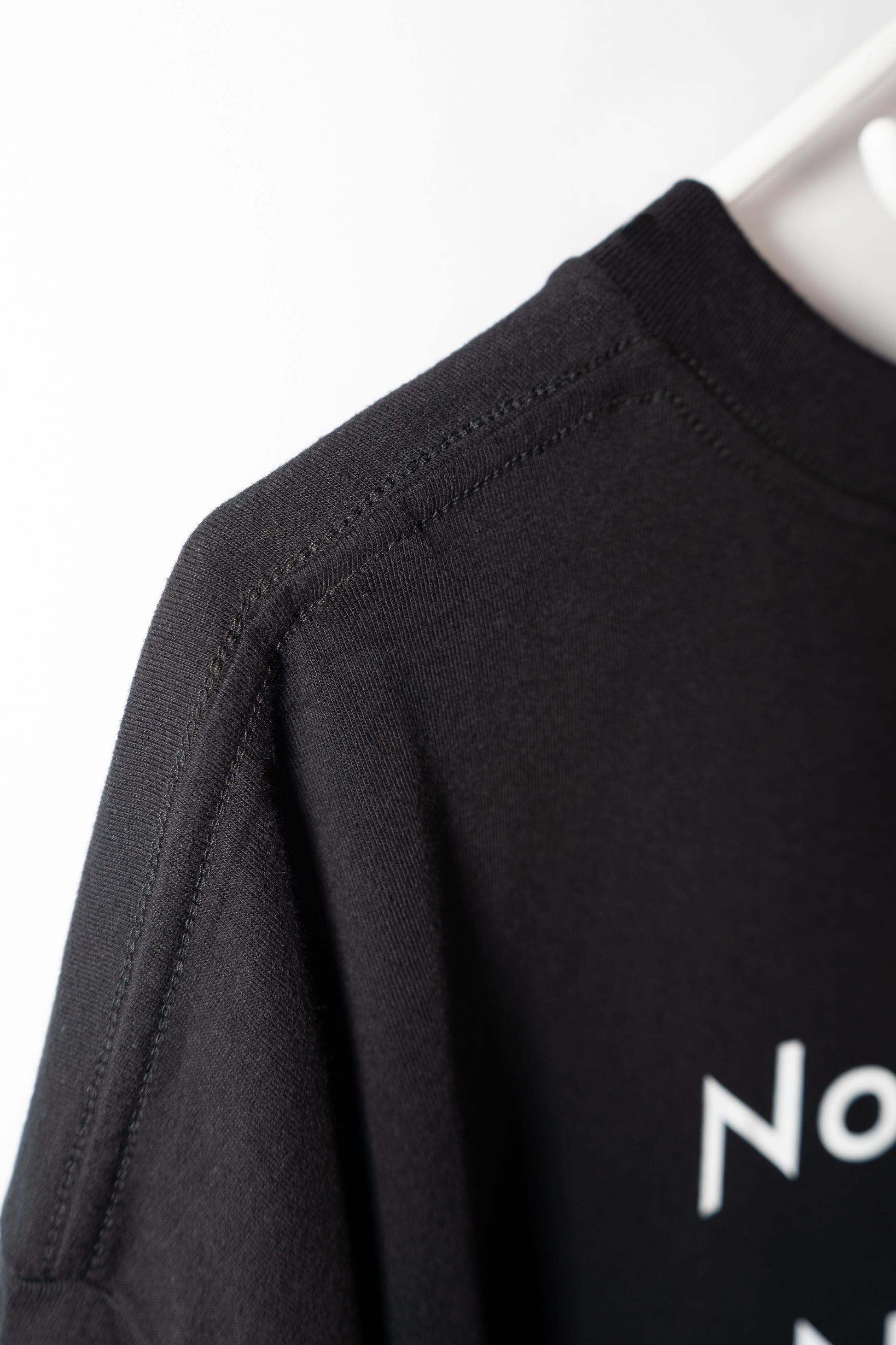 DL_Tee_Results_SideNeckDetail04
Alt-Text: Side close-up of the Dunya Lions t-shirt collar with partial print: "No..." visible.
