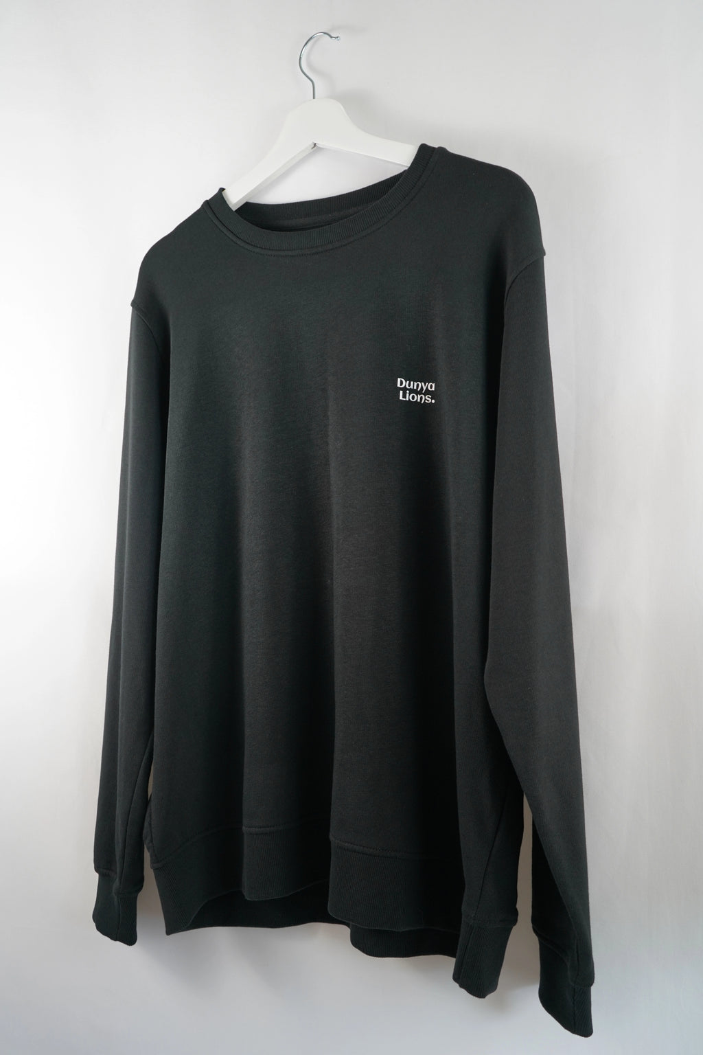 schwarzer Dunya Lions sweater frontal hängend fotografiert - minimalistischer look mit dezentem front-print