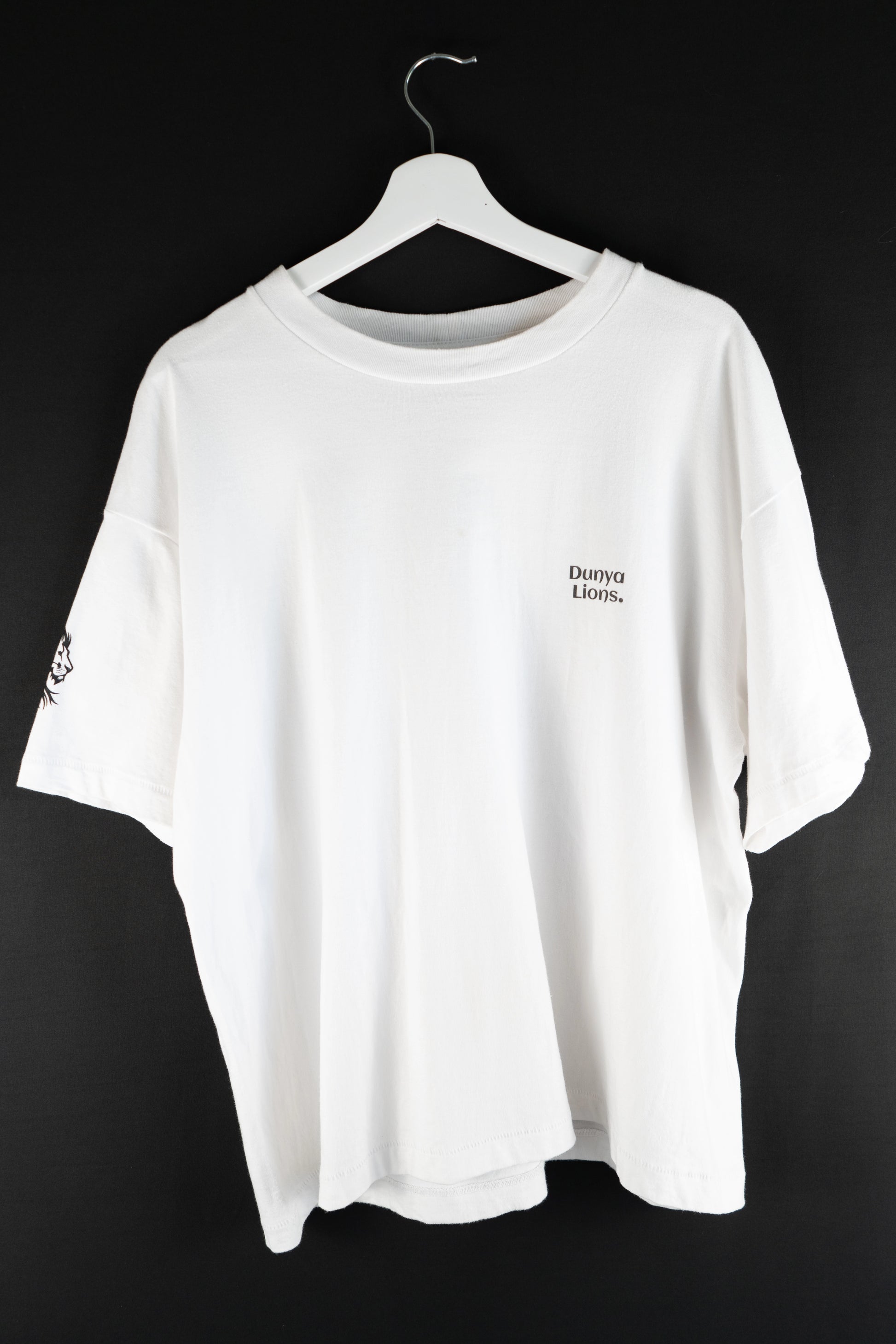 White oversized T-shirt with small Dunya Lions chest print, minimalist streetwear style.