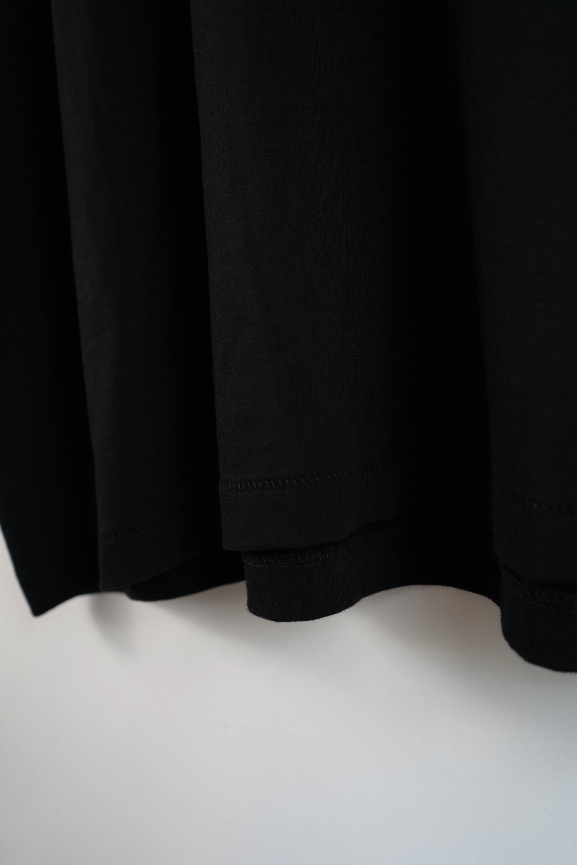 Detailaufnahme des unteren Shirt-Saums vom Dunya-Lions-Shirt ‚Just Return.‘ – klare Nähte, schwere Qualität, cleaner Fall.