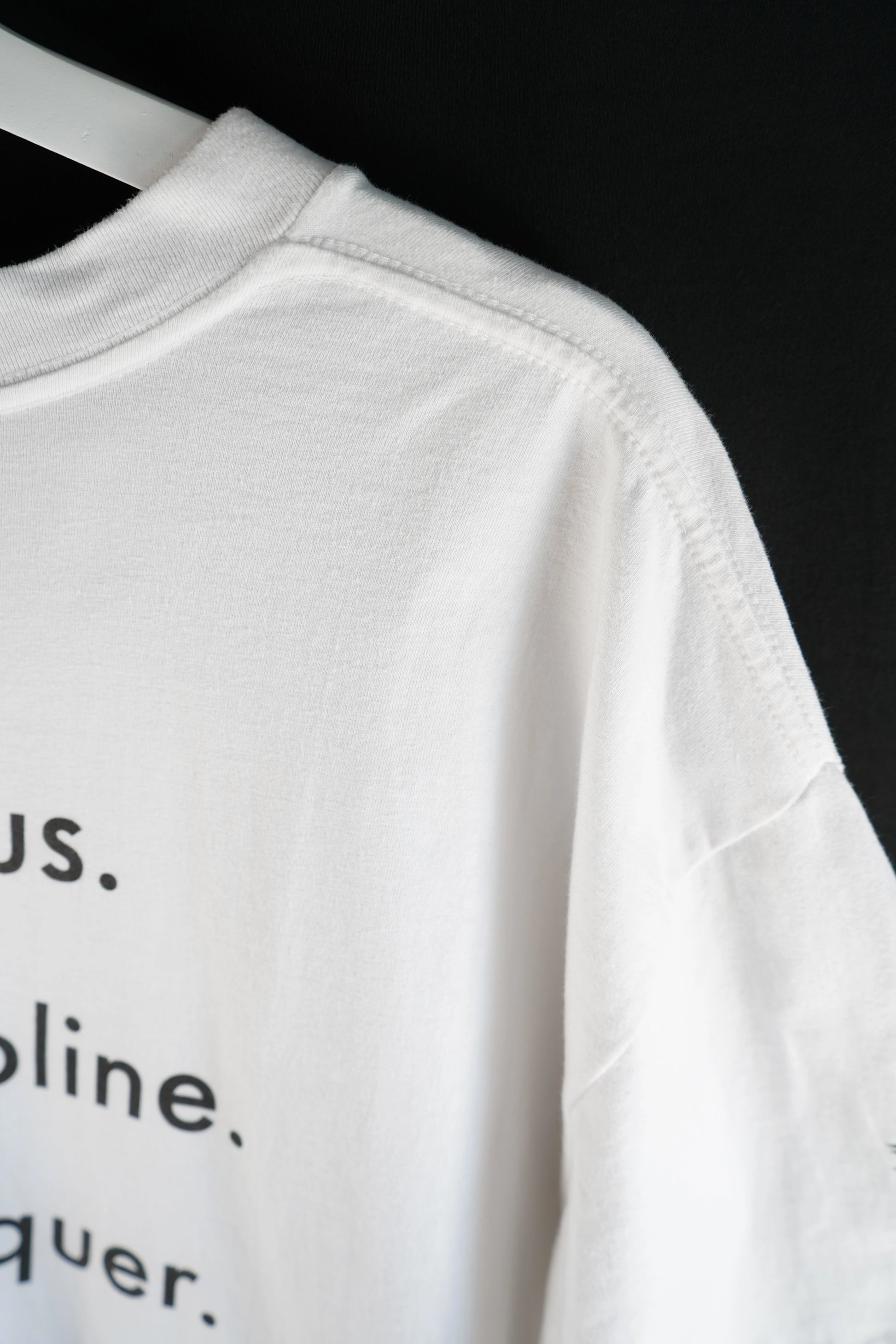 Side view of white oversized T-shirt with focus. discipline. conquer. 